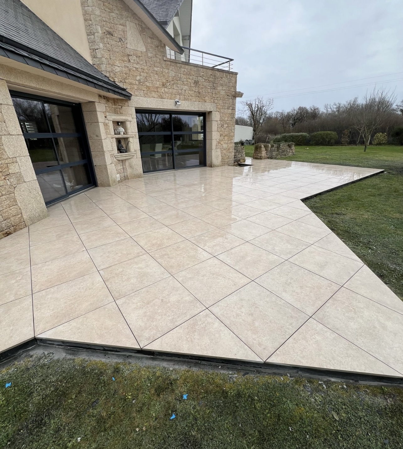 Grande terrasse carrelage beige maison en pierre bretonne